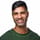 Khurram Naik smiling in a green sweater