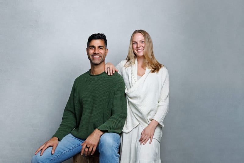 Khurram Naik and Emma seated together against a grey background